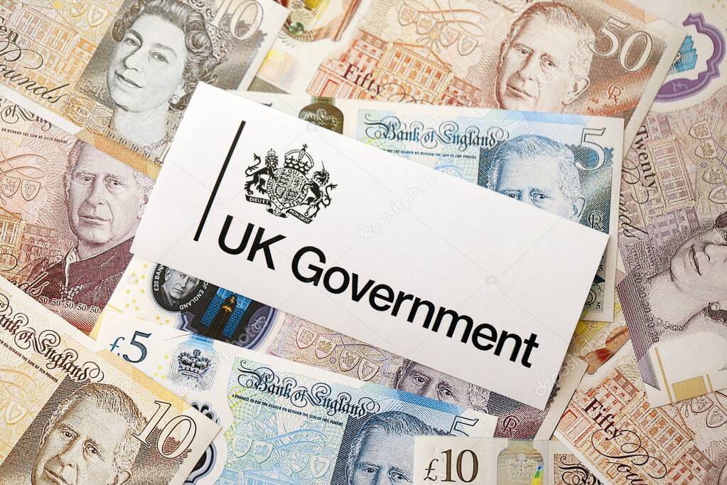 KYIV, UKRAINE - SEPTEMBER 17, 2025 Government GOV UK logotype sticker lies on British pounds money bills close up