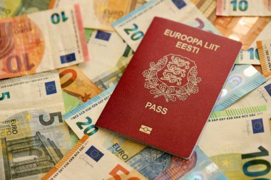 Estonya pasaportu, yakın plandaki büyük miktardaki avroluk para banknotlarına dayanıyor. Avrupa 'da zengin yaşam ve seyahat kavramı