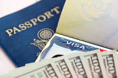 Passport and US Visa for immigration with many money bills close up. Concept of immigration visa and taxes for travel close up