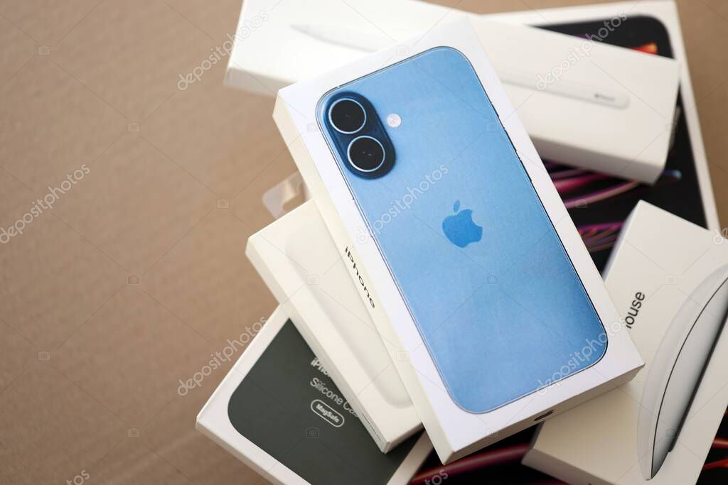 KYIV, UKRAINE - SEPTEMBER 21, 2025 Apple iPhone 17 Mist Blue box and other apple products on cardboard surface close up