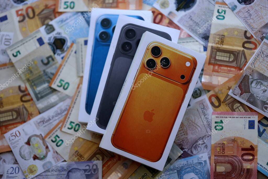 KYIV, UKRAINE - SEPTEMBER 21, 2025 Apple iPhone 17 Pro Max Cosmic Orange box on big amount of GB pounds and euro bills close up