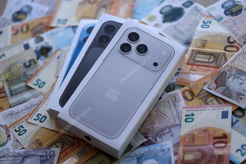 KYIV, UKRAINE - SEPTEMBER 21, 2025 Apple iPhone 17 Pro Max Silver box on big amount of GB pounds and euro bills close up