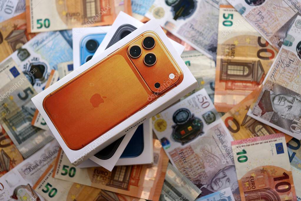 KYIV, UKRAINE - SEPTEMBER 21, 2025 Apple iPhone 17 Pro Max Cosmic Orange box on big amount of GB pounds and euro bills close up