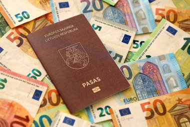 Litvanya pasaportu büyük miktarda avroluk para banknotlarına yakın duruyor. Avrupa 'da zengin yaşam ve seyahat kavramı