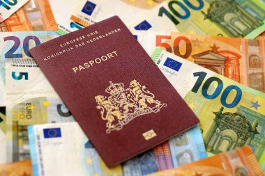 Hollanda pasaportu, yakın plandaki büyük miktardaki avroluk para banknotlarına dayanıyor. Avrupa 'da zengin yaşam ve seyahat kavramı