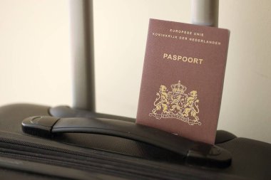 Netherlands passport on touristic baggage luggage in airport close up. Travel and tourism in Europe concept