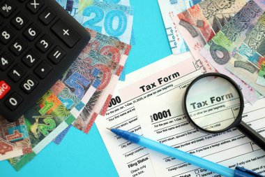 Kuveyt dinarı para faturaları ve mavi üzerine yakın vergi formlu hesap makinesi. Vergi ve muhasebe kavramı