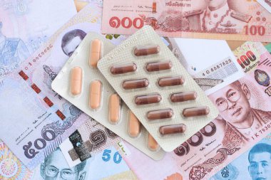 Tayland baht para birimi faturaları ve ilaç hapları. İlaç ve eczane kavramı