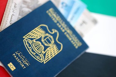 Birleşik Arap Emirlikleri kara para ve pasaport banknotları bayrağa yakın duruyor. Seyahat ve tatil kavramı