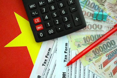 Vietnam çadırı para faturaları ve vergi formlu hesap makinesi yakın plan. Vergi ve muhasebe kavramı