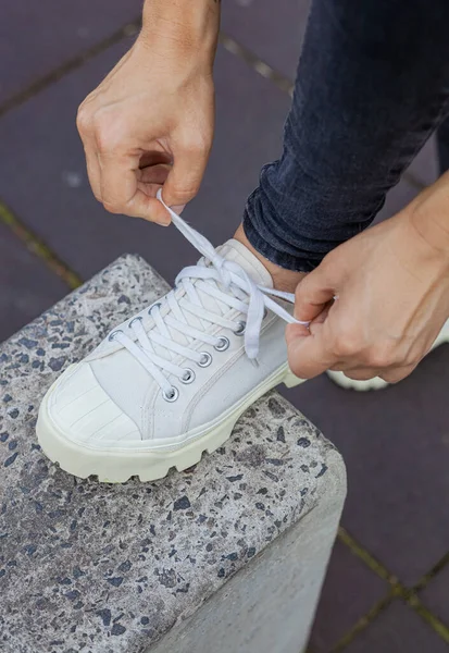 Gadis Dengan Sepatu Putih Dan Jeans Hitam Mengikat Tali Sepatunya — Stok Foto