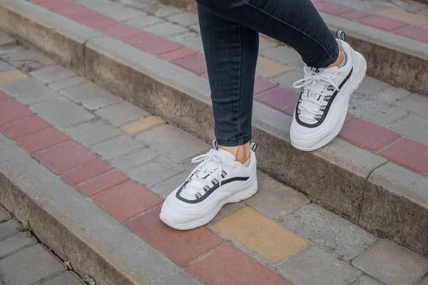 Sapatilhas Brancas Nos Pés Uma Menina Jeans Preto Rua — Fotografia de Stock