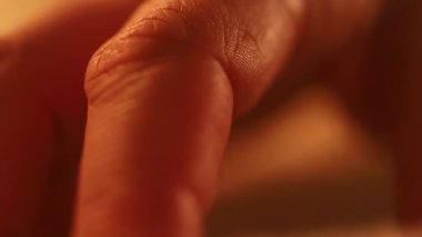 Yatakta sığ bir tarlada bir kadının elinin ayrıntıları. sarı, kırmızı ışık.