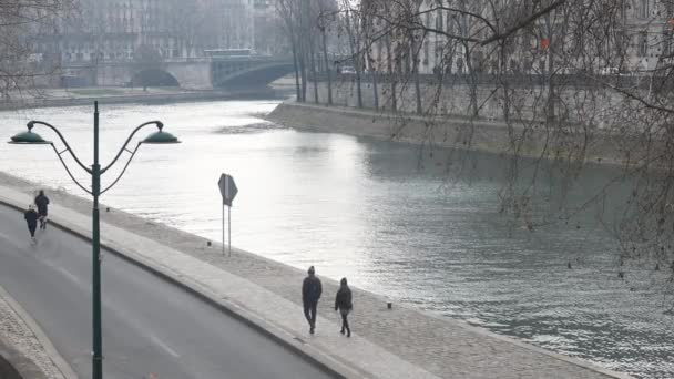 フランスの首都パリのセーヌ川沿いを歩く人々は — ストック動画