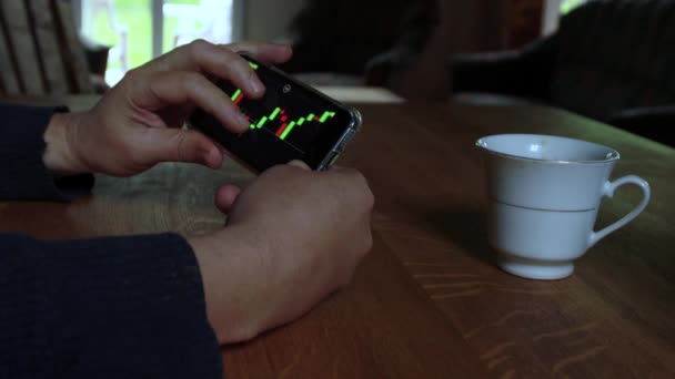 Man Controleert Aandelenmarkt Grafiek Zijn Mobiele Telefoon Thuis Business Finance — Stockvideo