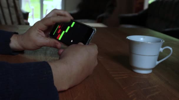 남자는 집에서 자신의 전화에 차트를 확인합니다 비즈니스 고품질 비디오 — 비디오