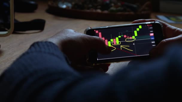 Man Controleert Aandelenmarkt Grafiek Zijn Mobiele Telefoon Thuis Business Finance — Stockvideo