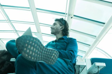 Genç bir Latin Amerikalı beyaz adamın portresi. İçerde ve havaalanında bilgisayar üzerinde çalışıyor.. 