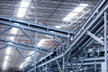 Modern taşıma bantlarının görüntüsü büyük bir depoda kutuları taşımaya hazır.