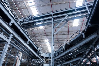 Modern taşıma bantlarının görüntüsü büyük bir depoda kutuları taşımaya hazır.