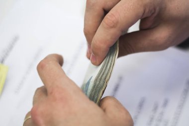 Değişim bürosu / bankada çalışan iş adamının insan eli. O para sayıyor ve bir müşteriye nakit para veriyor. Brezilyalı Reais.