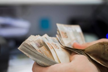 Değişim bürosu / bankada çalışan iş adamının insan eli. O para sayıyor ve bir müşteriye nakit para veriyor. Brezilyalı 50 reais fatura.