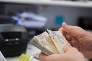 Değişim bürosu / bankada çalışan iş adamının insan eli. O para sayıyor ve bir müşteriye nakit para veriyor. Brezilyalı 50 reais fatura.
