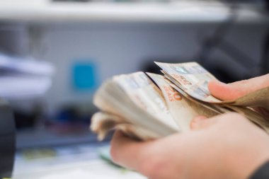 Değişim bürosu / bankada çalışan iş adamının insan eli. O para sayıyor ve bir müşteriye nakit para veriyor. Brezilyalı 50 reais fatura.