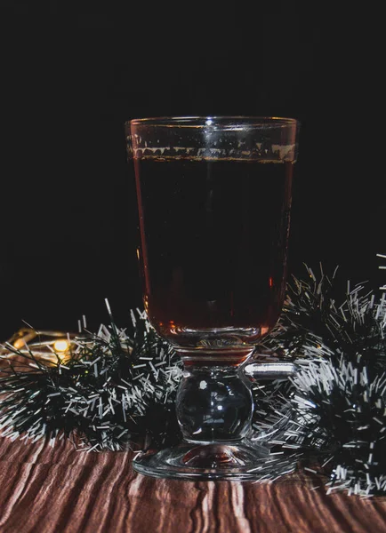 Noel süslemeli ve sıcak ışıklı bir fincan çay.