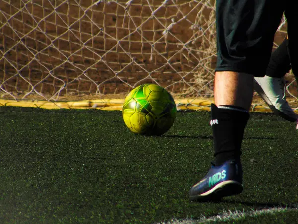 黄色い球が付いている合成草分野のサッカー選手の細部 — ストック写真