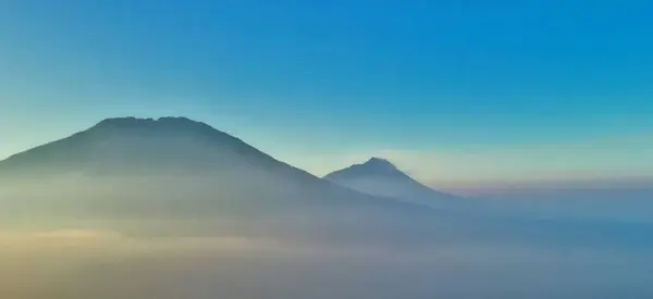 Sis ve güneşli dağ manzarası