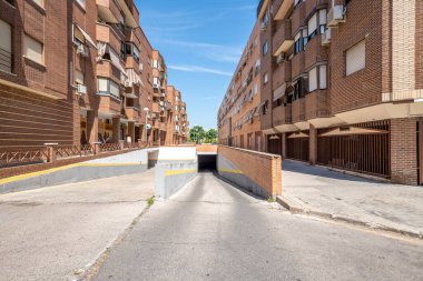 Mavi gökyüzü gününde bir şehir konutunun garajına giriş ve çıkış rampaları.