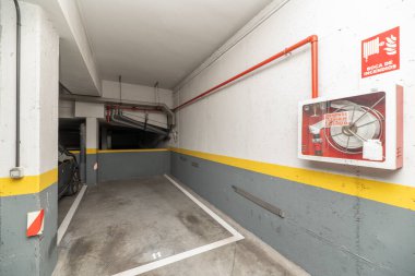 Yangın söndürme sistemi olan bir apartmanın zemin katındaki garaj.