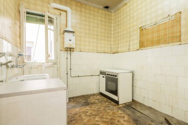 Karanlık zemini, beyaz kiremitleri ve duvarlarında sarı duvar kağıtları olan harap olmuş eski kirli mutfak, yalnız eski fırın ve gaz ısıtıcısı.