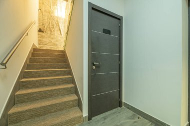 Lifli halı ve kilitli ıvır zıvır odası olan merdivenler.