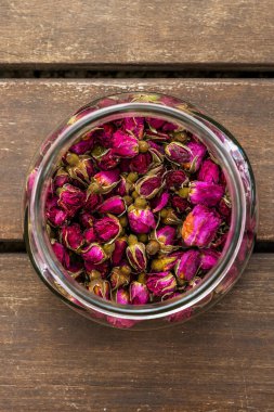 Akasya yüzeyinde çay gülleri olan cam kavanozlardan oluşan güzel bir kare.