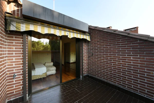 光沢のあるダークブラウンの石の床を持つ単一の家族の家の露出したタイルと屋根裏テラス — ストック写真