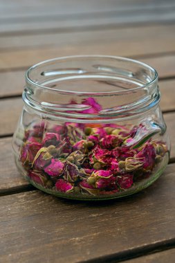 Çay yapmak için içi kurumuş gül tomurcuklarıyla dolu şeffaf cam kavanoz.