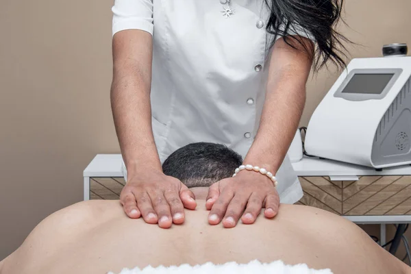 A masseuse\'s hands on the back of a client receiving a relaxing massage