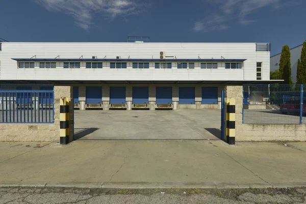 stock image Facade of an industrial warehouse with freight ports with blue doors