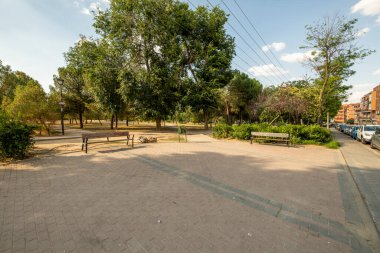 Ağaçlı bahçeler beton ve kum yolları olan şehir parkında ve açık kış gökyüzü şehrin hemen yanında.