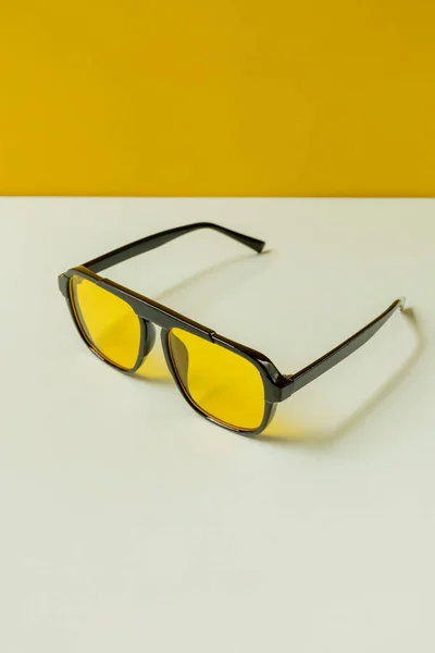 Par Gafas Sol Negras Con Lentes Amarillas Sobre Una Superficie — Foto de Stock