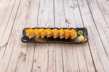 Avokado ve surimi ile doldurulmuş masago yumurtası ile uramaki California Roll tepsisi