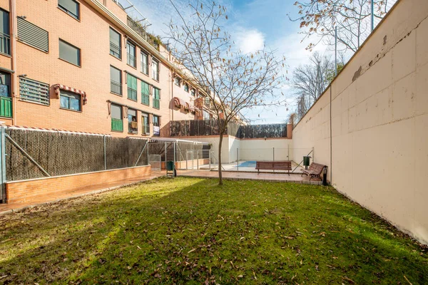 Facades of urban residential buildings with landscaped common areas and a pool covered with a canvas to spend the winter