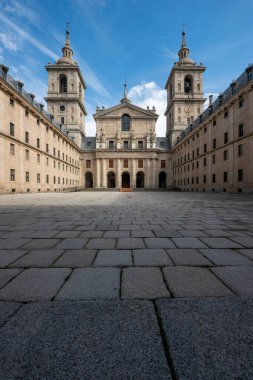 Madrid 'deki El Escorial Manastırı' nın girişlerinden birinin granit cephe cephesi. Merdivenleri korumak için ahşap bir rampa, granit zemin ve çan kuleleri olan merdivenler.