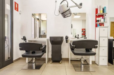 Siyah döşemeli ve uzun kollu saç kurutma makineli güzellik salonu için çift kişilik koltuklar.