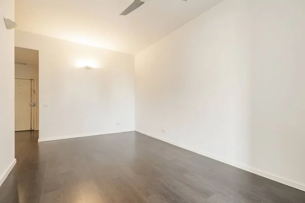暗いラミネート床と装飾されていない白い壁と空のリビングルーム — ストック写真