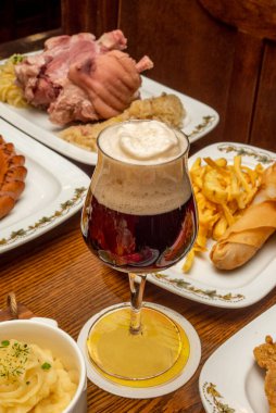 Tipik gastronomi yemekleriyle çevrili bir bardak güçlü Alman birası.