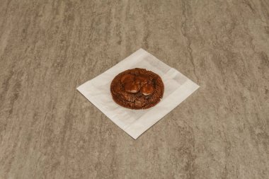 Çikolata parçacıklı kurabiye, Amerika kökenli, çikolata parçalı, gri bir masanın üzerinde bulunan bir kurabiyedir.