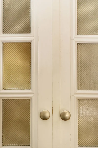 stock image Vintage wooden door with translucent glass and small circular metal knobs